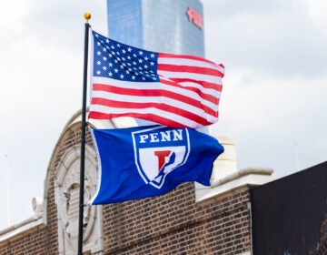 An American flag flying with a Penn flag