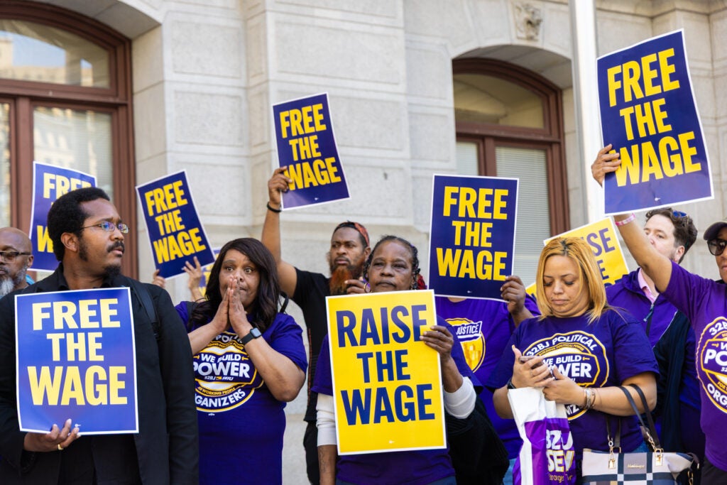 Union members at the rally holding signs saying "Raise the wage."