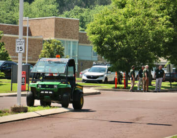 Security guards stand outside the entrance to Pennridge High School in Perkasie, where students were holding a memorial for children killed in the Uvalde school shooting. Members of the press were not allowed to attend the event. (Emma Lee/WHYY)