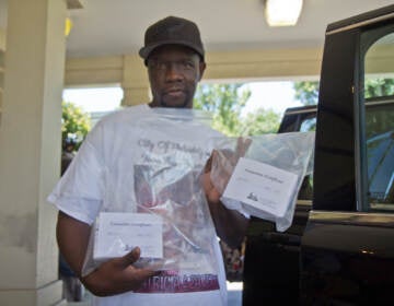 Lionel Dotson holds up a bag containing his sisters' remains