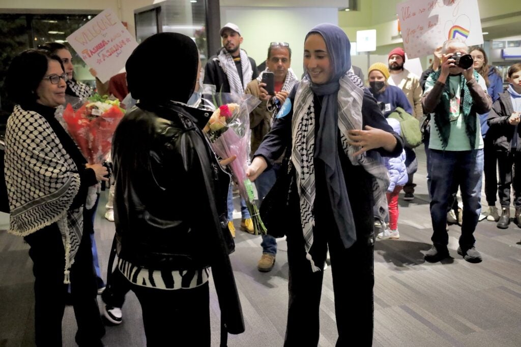 A woman is greeting Abbas with flowers