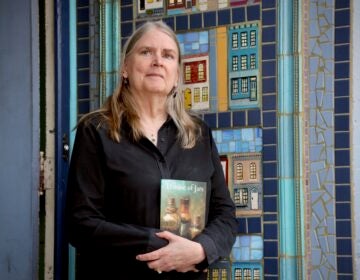 Alison Lewis holding her book