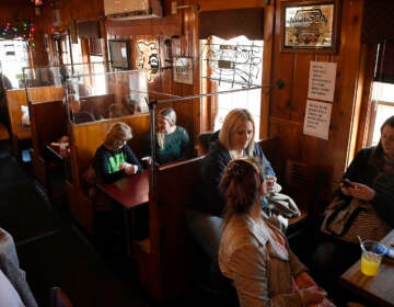 Diners eat and drink at the Hungry Rhino restaurant in Windsor Locks, Conn., Friday, March 19, 2021. Beginning today, limits have been lifted at Connecticut restaurants, non-theater indoor recreation centers, libraries, museums, aquariums, gyms and fitness centers, retail shops, offices, personal services establishments and houses of worship. Mask-wearing, distancing and cleaning protocols will still be required. (AP Photo/Jessica Hill)
