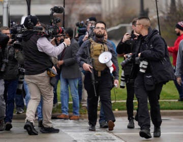 A protester carrying a rifle leaves the  the Kenosha County Courthouse after speaking with Kenosha County Sheriffs Department officers, Wednesday, Nov. 17, 2021 in Kenosha, Wis., during the Kyle Rittenhouse murder trial. Rittenhouse is accused of killing two people and wounding a third during a protest over police brutality in Kenosha, last year. (AP Photo/Paul Sancya)