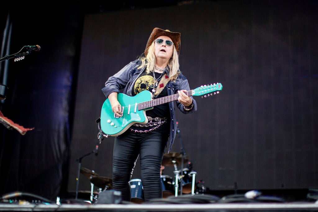 Musician Melissa Etheridge plays a blue electric guitar on stage