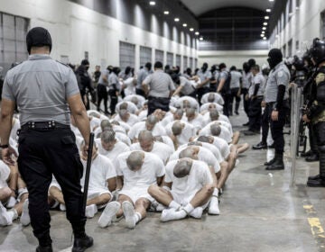 People are held in detention wearing white clothes in an El Salvadoran prison