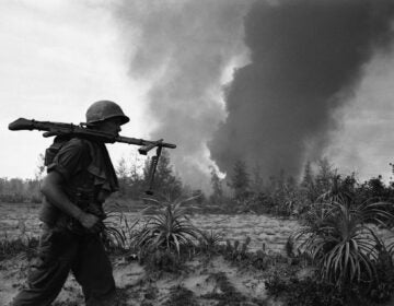 A U.S. Infantryman of the 25th division balances a M60 machine gun on his shoulder as he rushes into position behind smoke rising from a burning village near Duc Pho, about 325 miles North of Saigon on July 31, 1967. Air strikes had been called in on the village when elements of the division met resistance during a search and clear operation. (AP Photo)