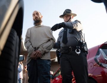 Cody Balmer escorted by an officer