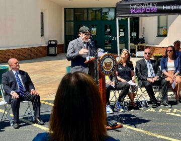 Daniel Elkin speaking at a podium at the press conference