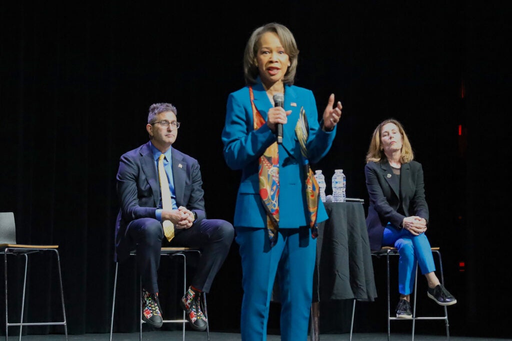 Lisa Blunt Rochester standing and speaking into a mic on stage during the town hall