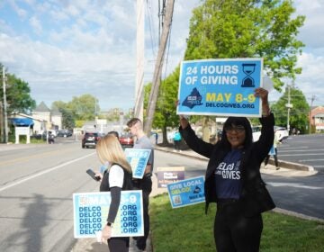 Delco Gives Day volunteers hold signs for the event