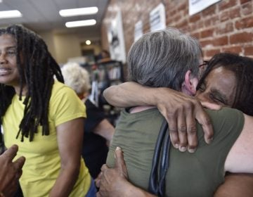 Janet Africa (right) embraces Betsy Piet while on the left, Janine Africa greets a well wisher. Janet and Janine Africa were recently released after serving 40 years in prison for their role in the shooting death of a police officer. (Jonathan Wilson for WHYY)
