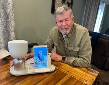 Anthony Niemiec with ElliQ, an AI companion robot, in Beacon, New York. (Dawn Attride/For WHYY)