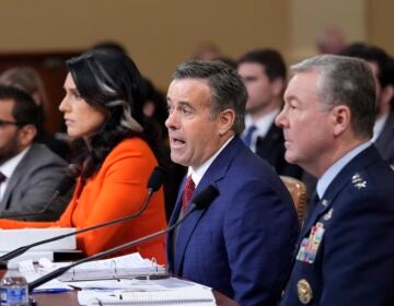 Intelligence officials sitting at a table during the hearing