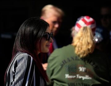 Laura Loomer walking past Donald Trump