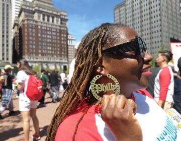 Tiphanie White shows off Philly earrings at the pep rally about volunteering in Philly for the semiquincentennial