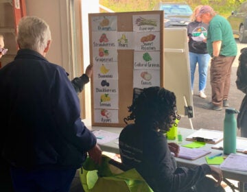 a list of foods offered at a table as residents stand in line
