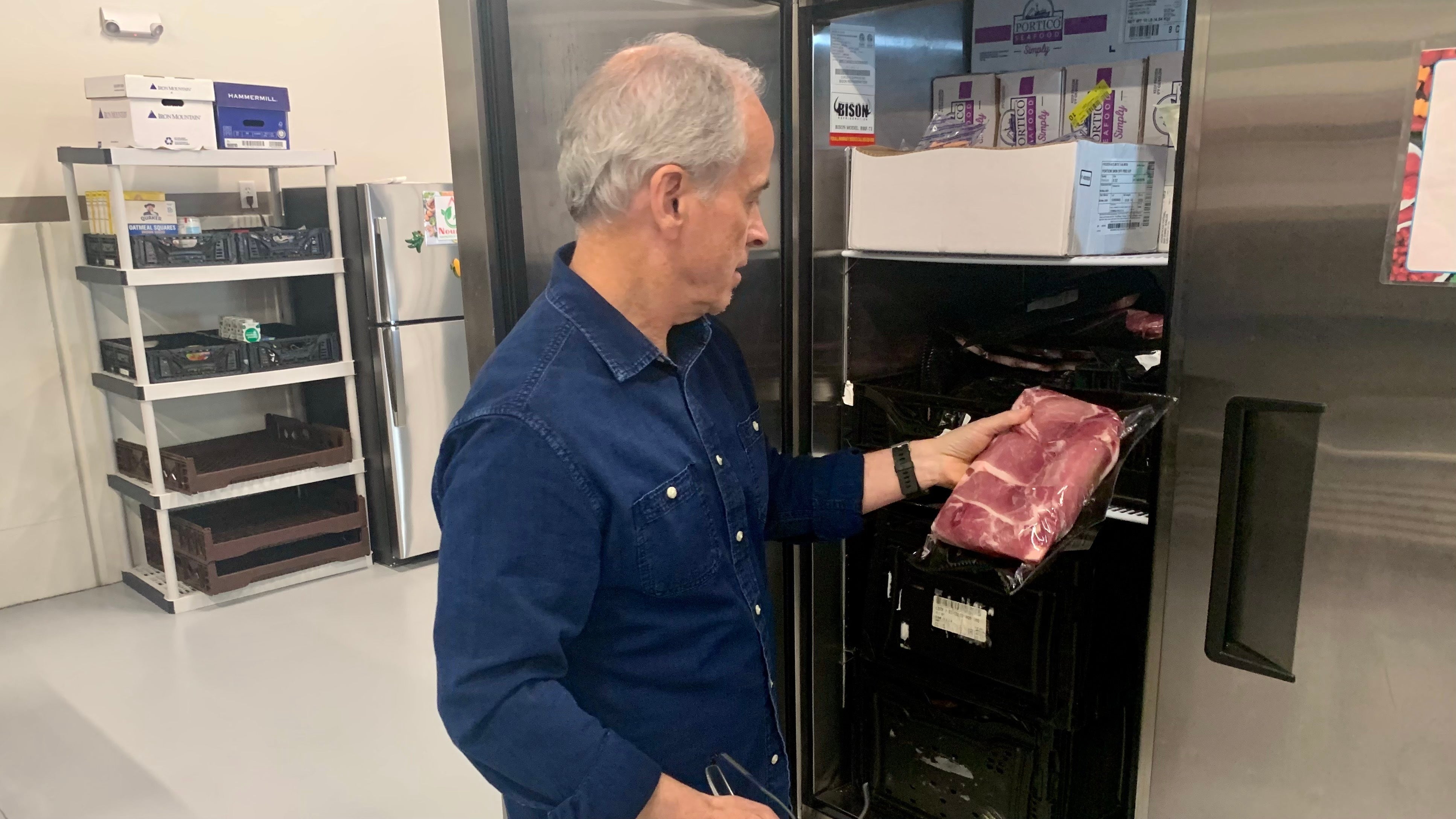 Rob Gurnee looking at and holding a piece of meat