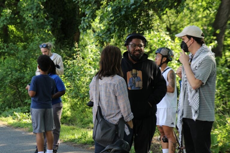 Philadelphians and loved ones of the Africa family on the sidewalk of Cobbs Creek Parkway