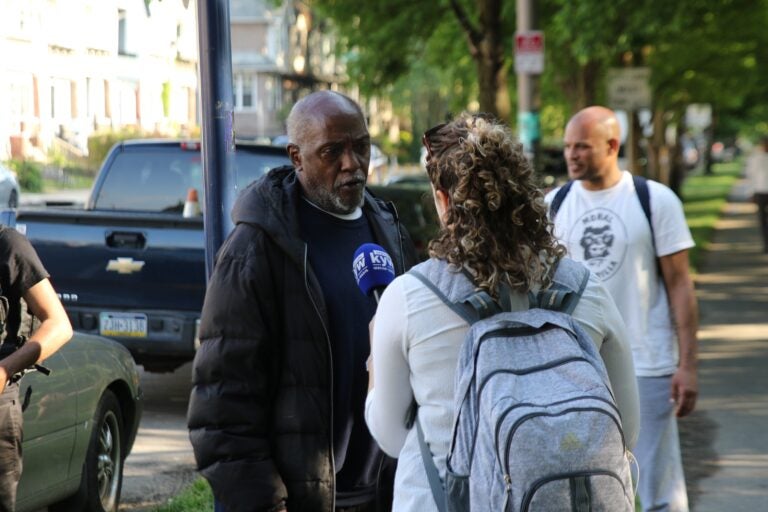 Philadelphians and loved ones of the Africa family on the sidewalk of Cobbs Creek Parkway