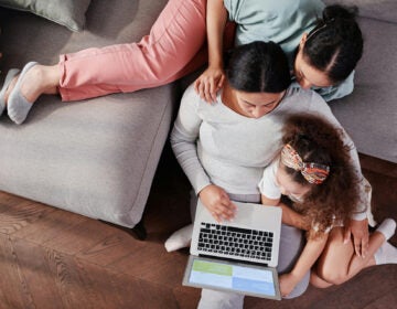 Mother and Daughters Sitting with Laptop