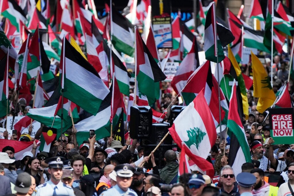 People march on the street holding Palestinian flags