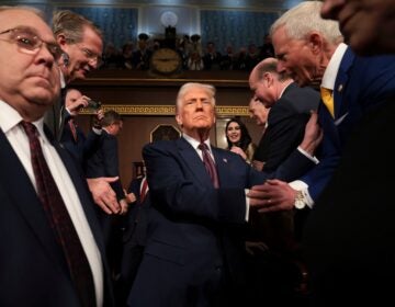 Trump shakes hands with people as he enters the senate floor