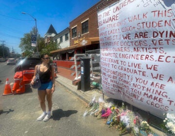 Crystal Sandoval stands by a memorial for the car crash at the University of Delaware