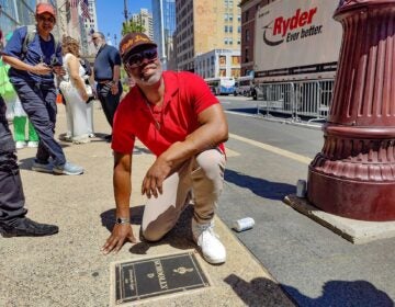 Schoolly D posing for a photo with his plaque on the walk of fame
